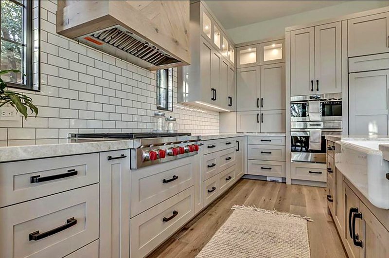 Finished greige/putty shaker kitchen with matte-black bar pulls, white subway tile to — kitchen by MNK Cabinet in metro Atlanta