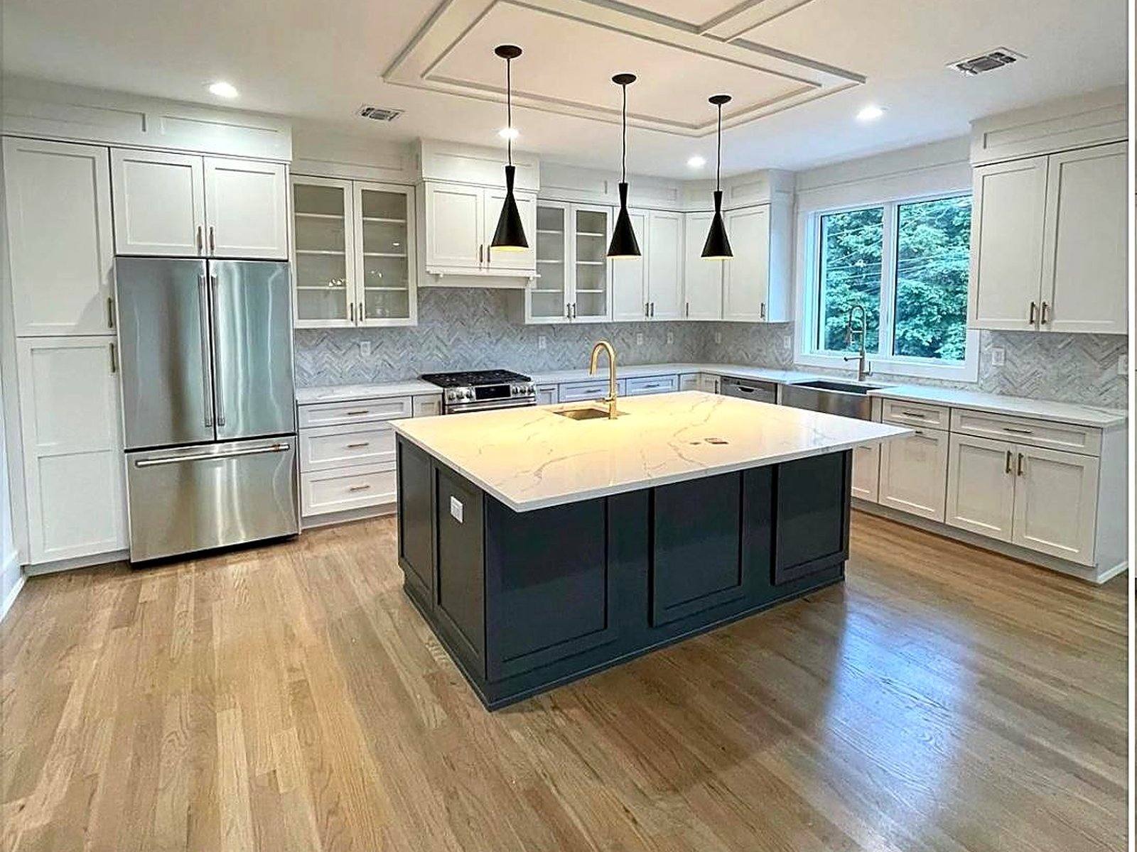 Bright white shaker kitchen with island by MNK Cabinet