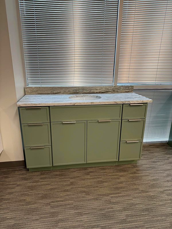 Sage green shaker vanity with brushed nickel bar pulls, gray-brown fantasy granite top — bathroom vanity by MNK Cabinet in Norcross, GA