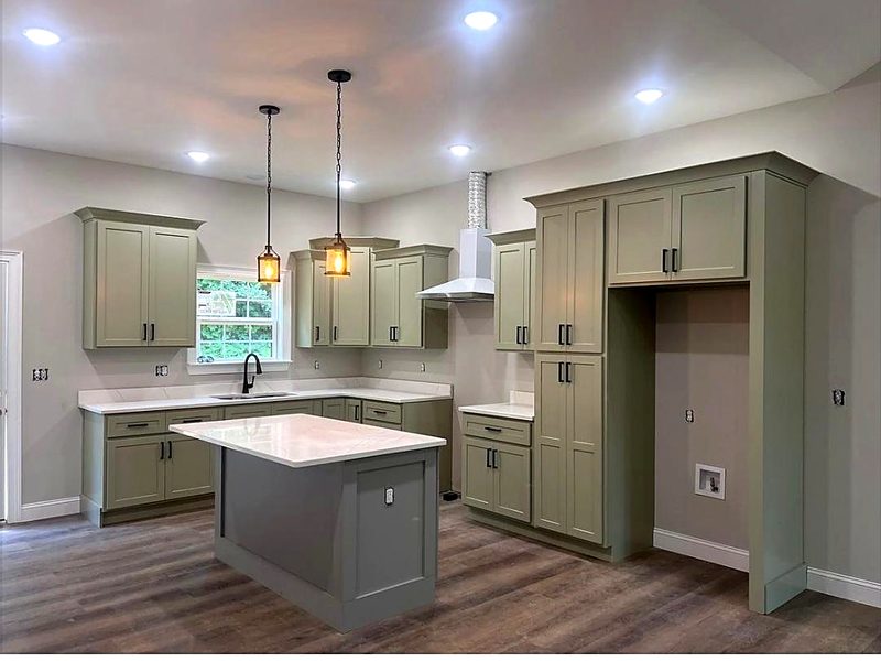 Sage green shaker cabinets with black bar pulls, matching gray-green shaker island — kitchen by MNK Cabinet in metro Atlanta