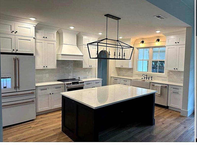 White shaker cabinets with black hardware, black/dark-navy shaker island with white — kitchen by MNK Cabinet in metro Atlanta