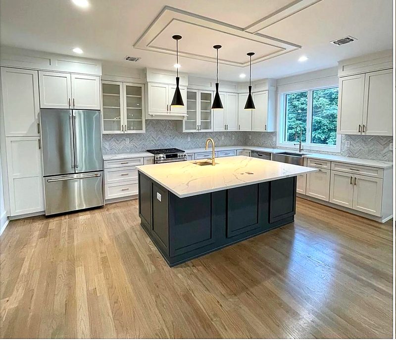 L-shaped kitchen with white shaker perimeter cabinets and glass-front uppers, dark navy — kitchen by MNK Cabinet in metro Atlanta