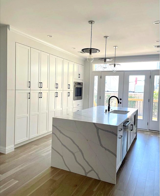 Finished white shaker kitchen with full-height pantry wall, large calacatta-look quartz — kitchen by MNK Cabinet in metro Atlanta