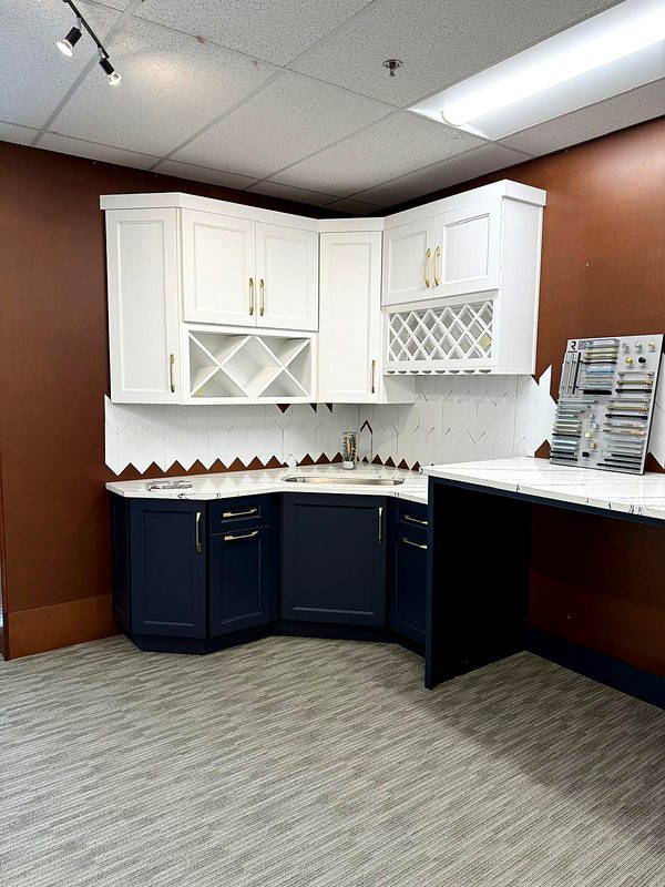 Two-tone corner display: white shaker upper cabinets with X-shaped and lattice — on display at MNK Cabinet's Norcross, GA showroom